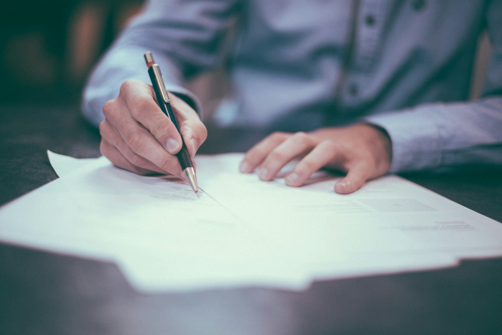Signing yacht closing and title-transfer documents at a desk